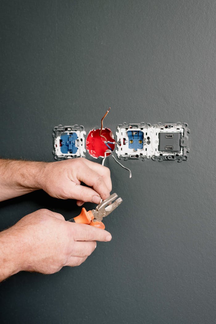 why-choose-us-01 Crop faceless electrician using pliers for installation sockets and switches in new apartment